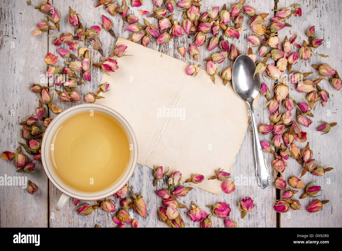 Tasse Tee mit rose Knospe und Vintage-Papier, Exemplar Stockfoto