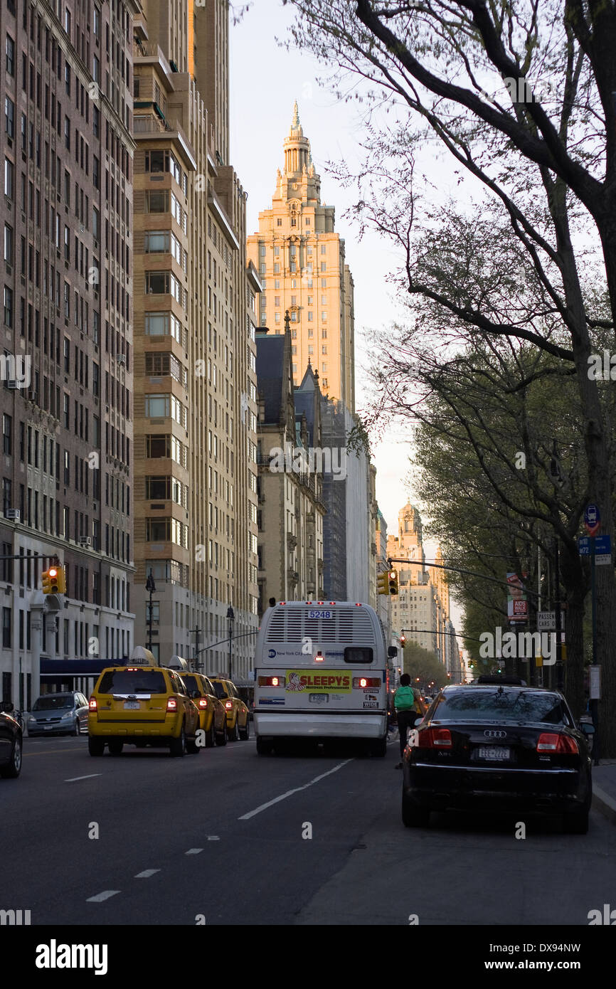 Eine MTA-Bus und eine Reihe von Taxis fahren nördlich vorbei an parkenden Autos am New Yorker Central Park West in 70th Street in Manhattan Stockfoto