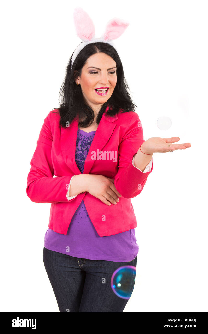 Glückliche Frau mit Hasenohren Fang eine Blase in ihre Handfläche isoliert auf weißem Hintergrund Stockfoto