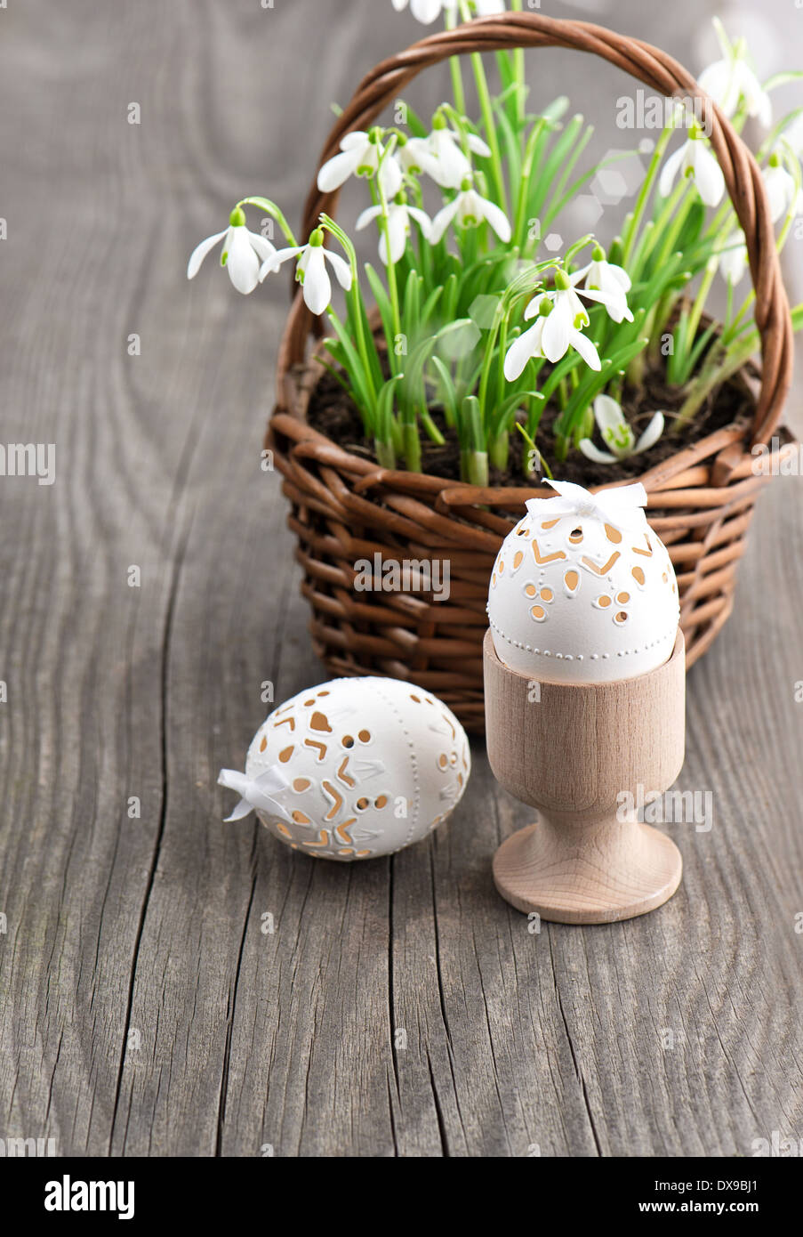 Oster-Deko mit Eiern und Frühlingsblumen. Schneeglöckchen auf hölzernen Hintergrund Stockfoto