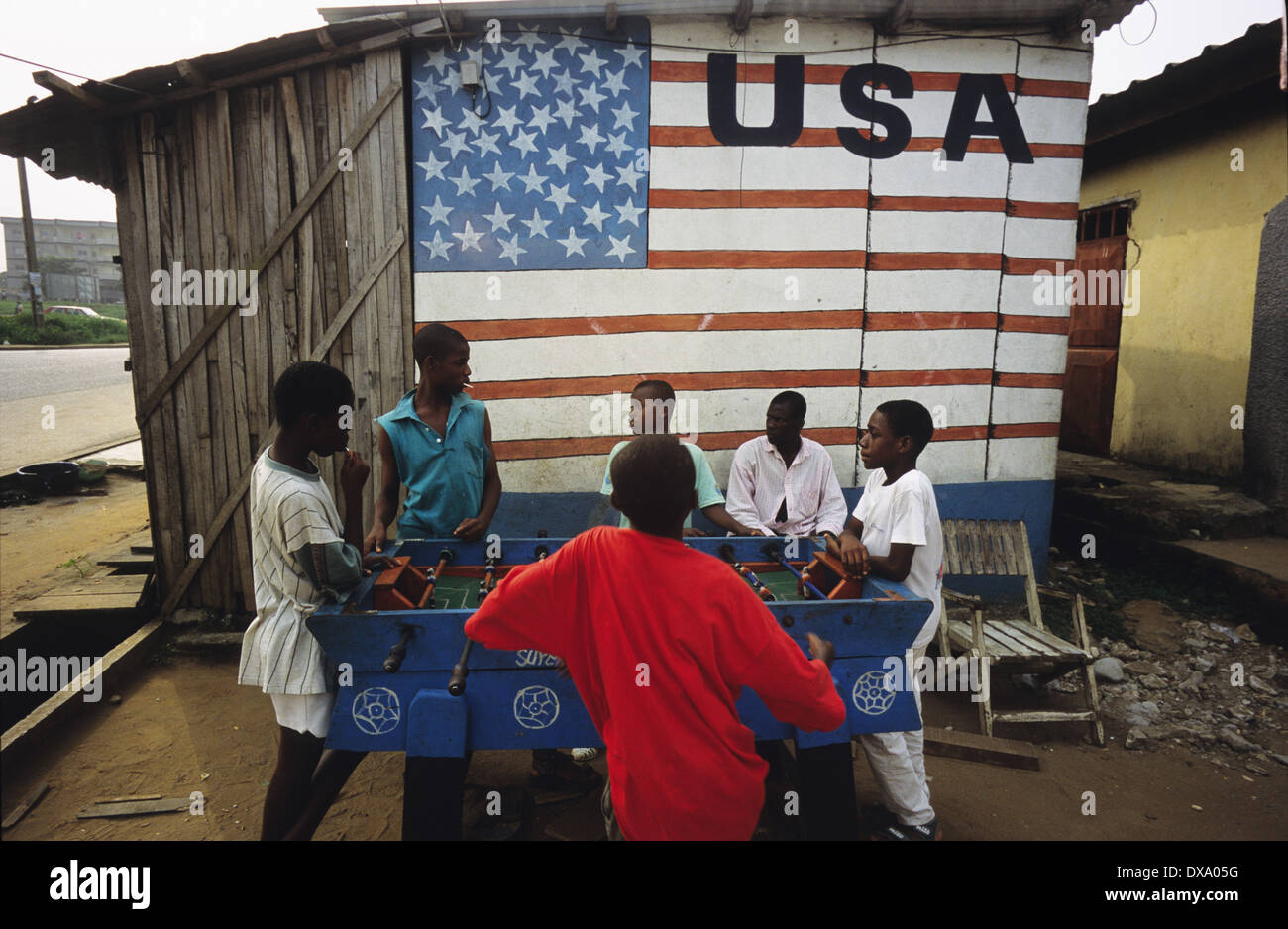 Kinder spielen Fußball unter amerikanischer Flagge Wandbild, Yopougon Township, gegenüber von Abidjan, Elfenbeinküste, Afrika Stockfoto