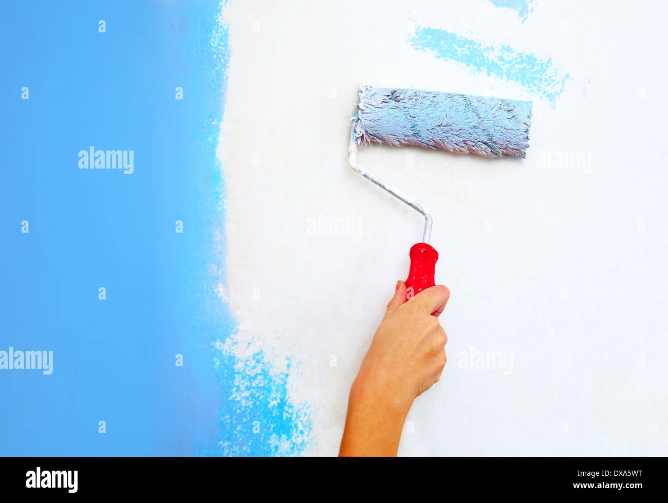 Hand mit Walze Pinsel Malerei Wand. Stockfoto