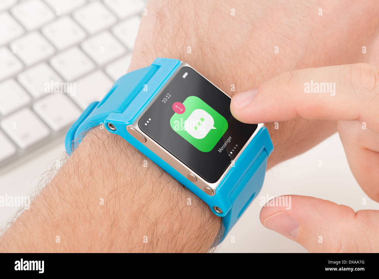 Männliche Finger tippt Messenger-Symbol auf blauem Smartwatch Stockfoto
