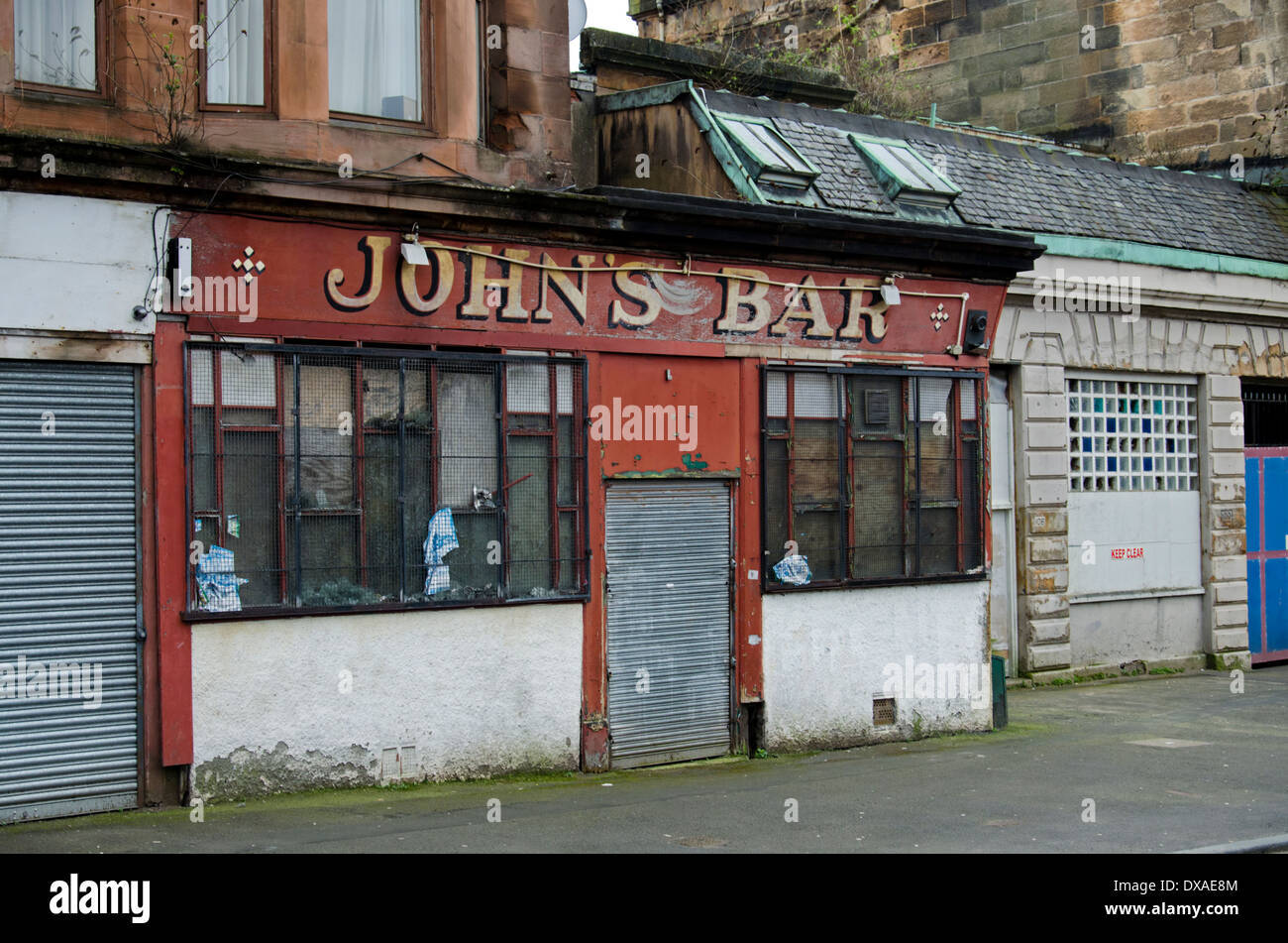 John's Bar, ein verfallenes Haus der Öffentlichkeit in Tobago Straße im Bereich Calton von Glasgow. Stockfoto