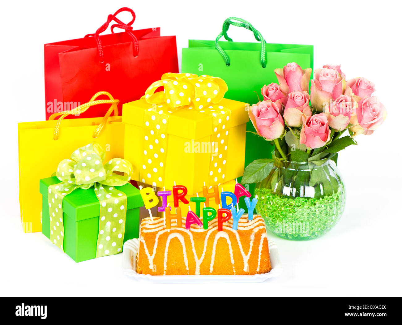 Geburtstagstorte mit Buchstaben-Kerzen, Blumen und Geschenke auf weißem Hintergrund Stockfoto