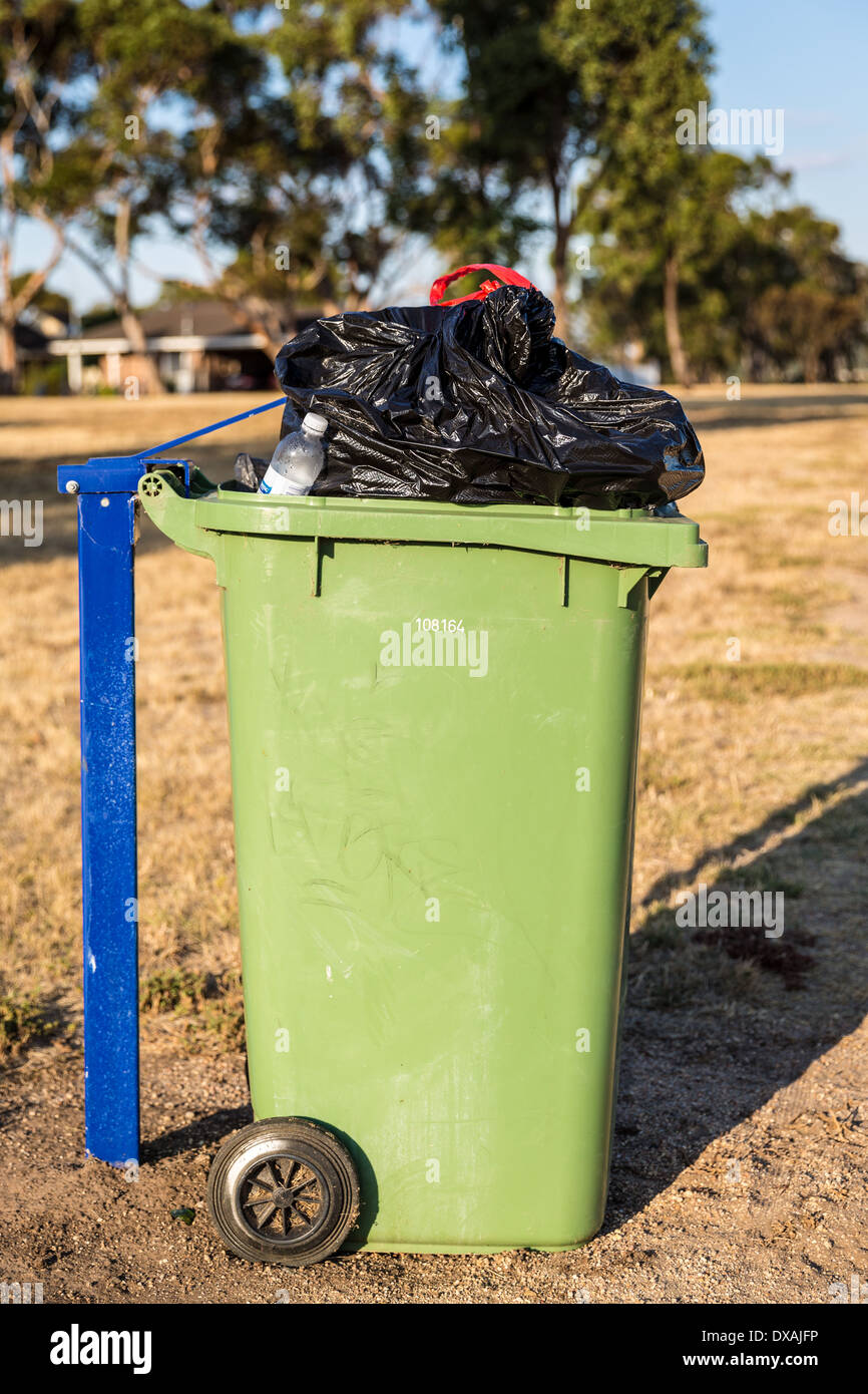 Wheelie bin im Park überfüllt. Stockfoto