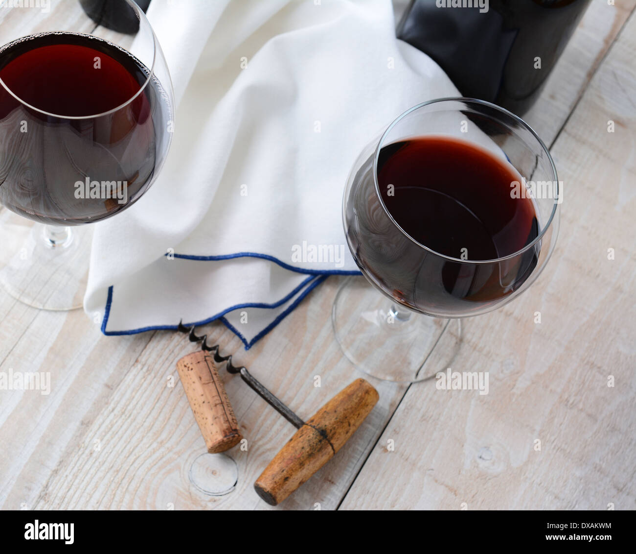 Schrauben Sie zwei Weingläser Rotwein auf einem Holztisch mit antikem Kork. Querformat aus einem hohen Winkel geschossen. Stockfoto