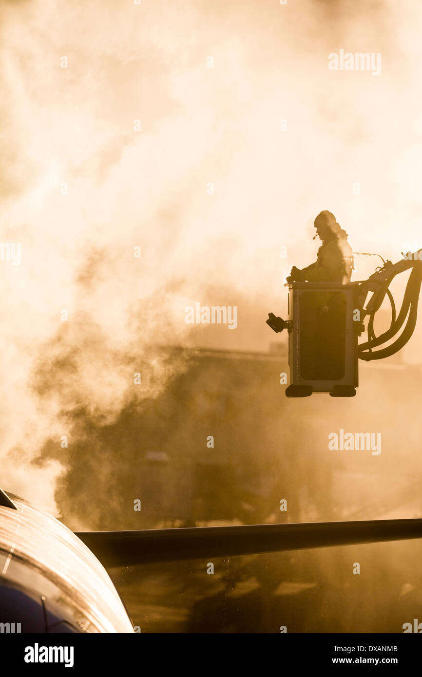 Ein Flugzeug Wartung Worker de-ices ein Flugzeug, bevor sie Calgary, Alberta während einem kalten Wintertag verlässt. Stockfoto