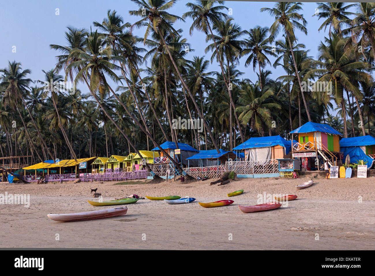 Strandhütten mit Kokospalmen im Hintergrund und Kajaks am Strand von Palolem Beach in Goa, Indien Stockfoto