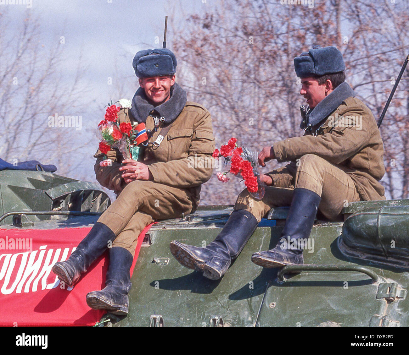 17. Februar 1989 - Termez, Usbekistan, RU - Holding Blumen gegeben Ihnen von Einheimischen, sowjetische Truppen der 103. wachen Luftlandedivision, 40. Armee, die letzten sowjetischen Soldaten, Afghanistan, oben auf einem gepanzerten Mannschaftswagen auf ihrem Weg zu einer Zeremonie in der Grenze Stadt Termez in die usbekische Sozialistische Sowjetrepublik zu verlassen, kurz nach der Überquerung der Brücke der Freundschaft über den Amudarja-Fluss verbindet der afghanischen Grenze Stadt von Hayratan mit Termez , in die usbekische Sozialistische Sowjetrepublik. Es war neun Jahre und 50 Tage nach intervenieren, um einen Staatsstreich durch eine marxistische Verbündete zu unterstützen (Credit-Bild: © Arnold D Stockfoto