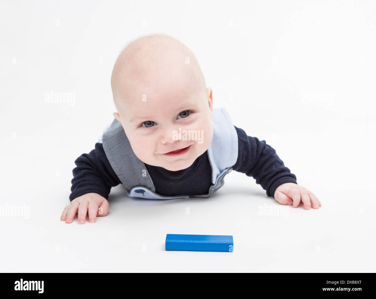 interessierten Baby mit Klötzchen auf Boden isoliert auf weiss Stockfoto