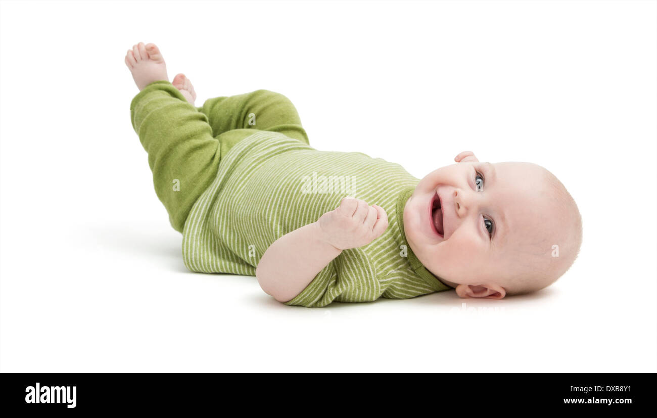 glückliches Baby in grüne Kleidung auf dem Rücken liegend. isoliert auf weißem Hintergrund Stockfoto