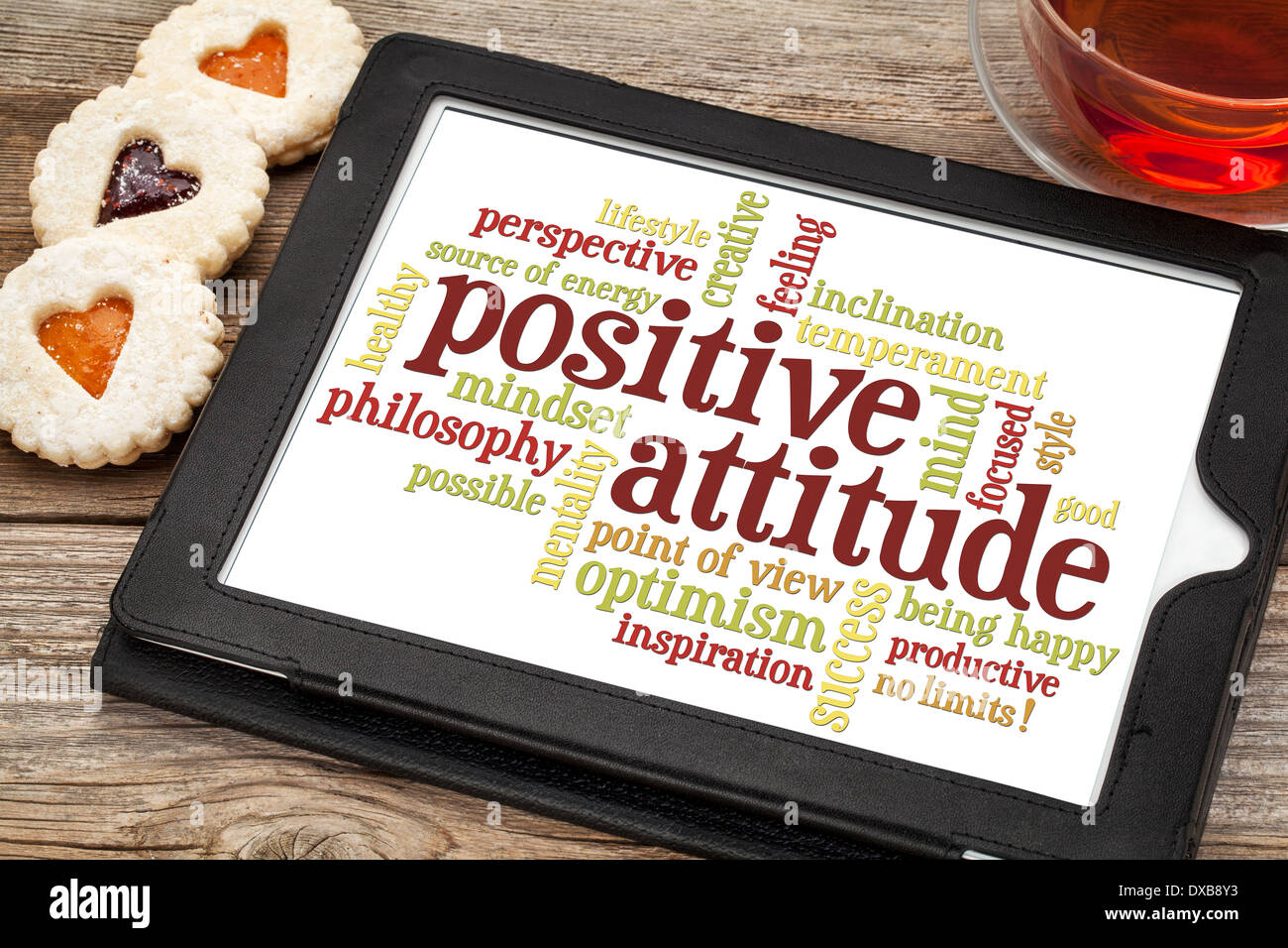 positive Einstellung Word cloud auf digitale Tablett mit einer Tasse Tee und Cookies Herz Stockfoto