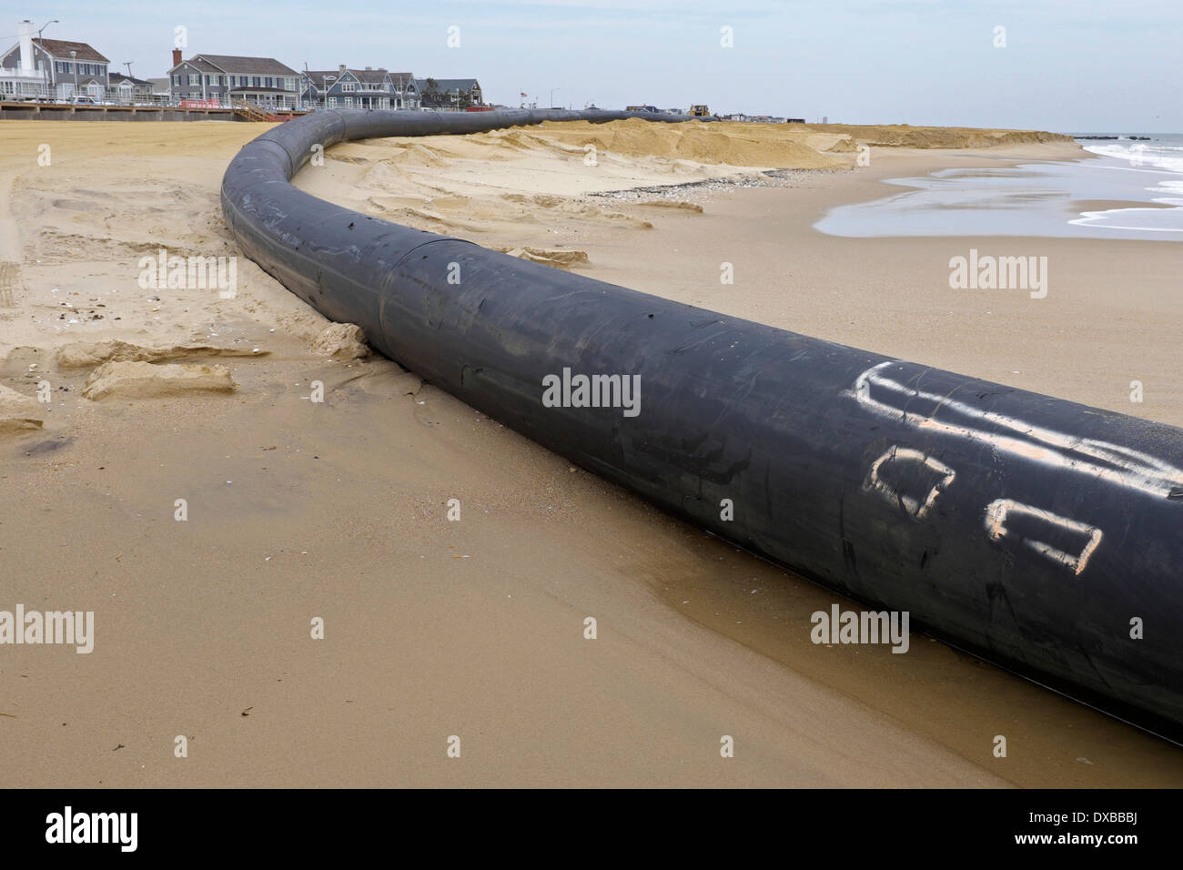 Baggerarbeiten Rohr führenden aus dem Wasser und bis auf an den Strand Stockfoto