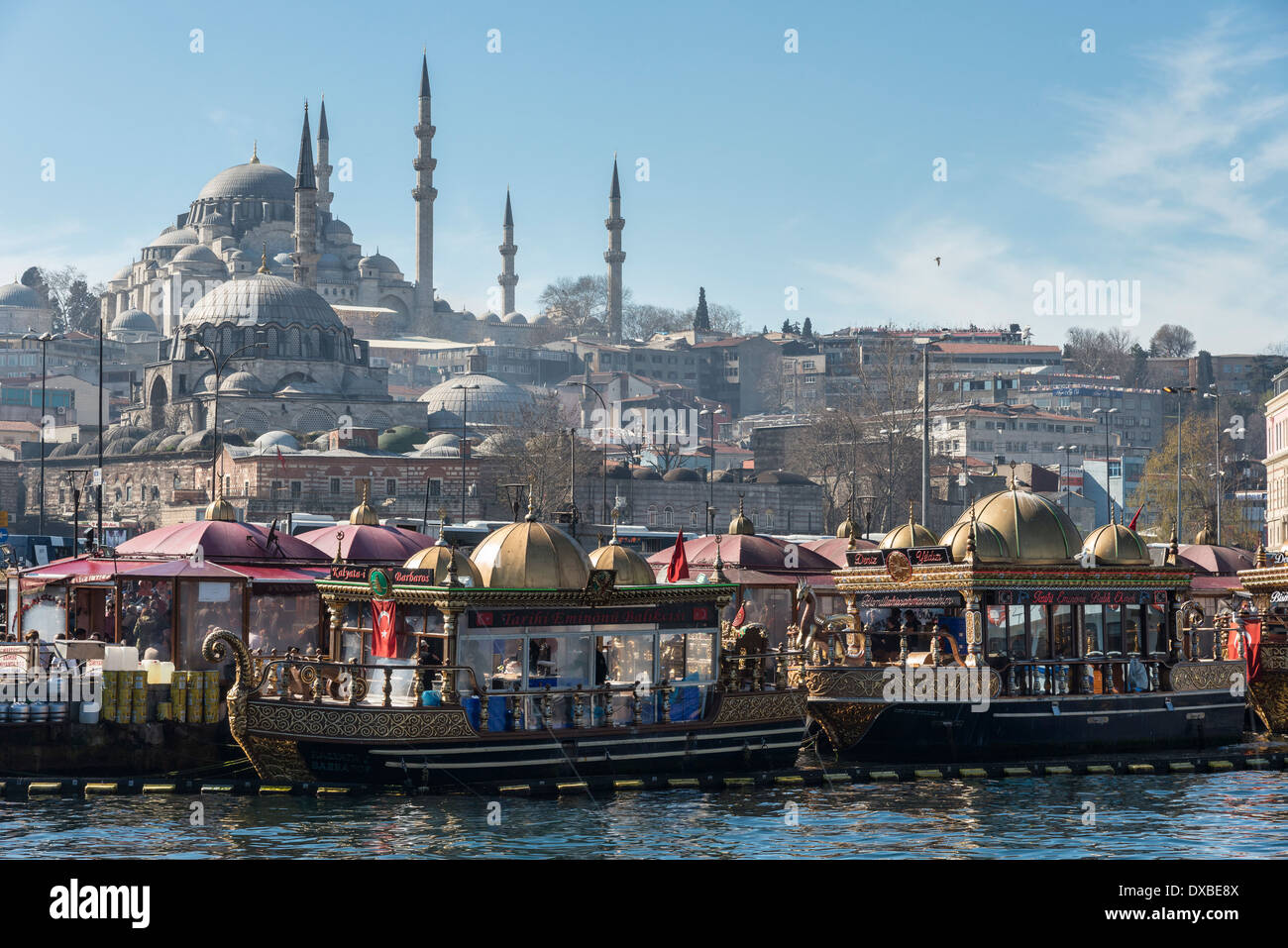 Schwimmenden Fisch-Restaurants an der Uferpromenade in Eminönü mit der Süleymaniye-Moschee auf die Skyline. Istanbul, Türkei. Stockfoto