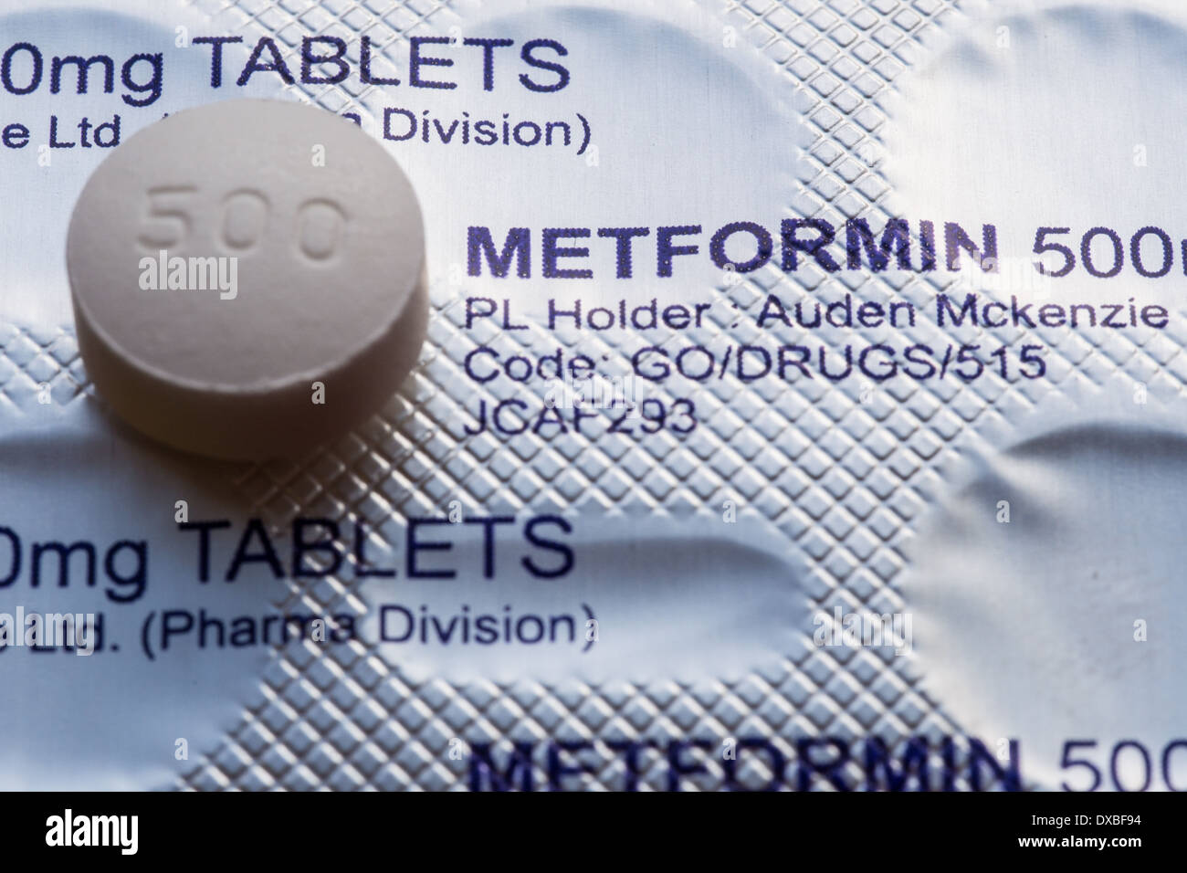 Eine Metformin Tablette gegen eine Blisterpackung erschossen. Stockfoto