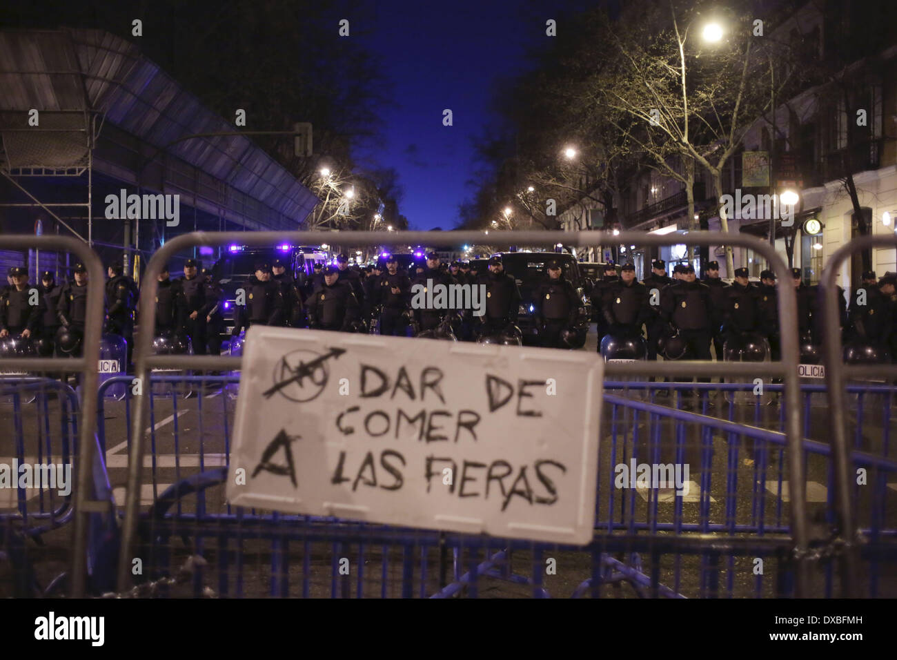 Madrid, Spanien. 22. März 2014. Polizei in Kampfmontur stehen neben "Partido Popular" (PP) Hauptquartier während einer Protestaktion namens '' marschieren würde '' gegen die Regierung Banner Sais '' nicht füttern die Tiere '' in Madrid, Spanien, Samstag, 22. März 2014. Die spanische Polizei und Demonstranten stießen während einer Demonstration gegen Sparpolitik, die Zehntausende von Menschen ins Zentrum von Madrid am Samstag zog am Ende. Die Polizei sagte in einer Erklärung, mehr als 100 Personen verletzten 55 Offiziere waren, die einige von ihnen mit schweren Wunden und 29 Personen wurden verhaftet. (Kredit-Bild: © Rodrigo Garcia/NurPhoto/ZUMAPRESS Stockfoto