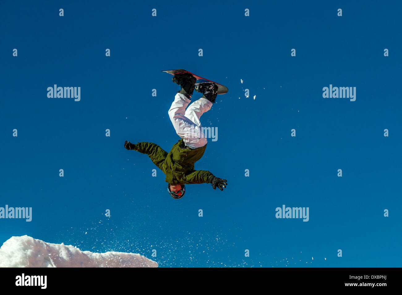 Person lernen Snowboard springen: Airborne Snowboarder auf den Kopf, nachdem es auf einen Sprung Stockfoto