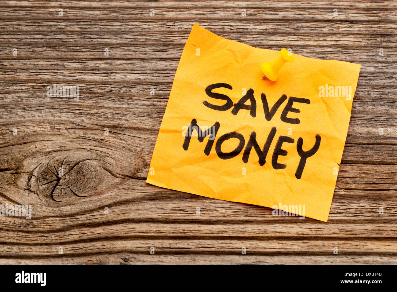 sparen Sie Geld gelbe Notiz gegen gemaserte Holz Stockfoto
