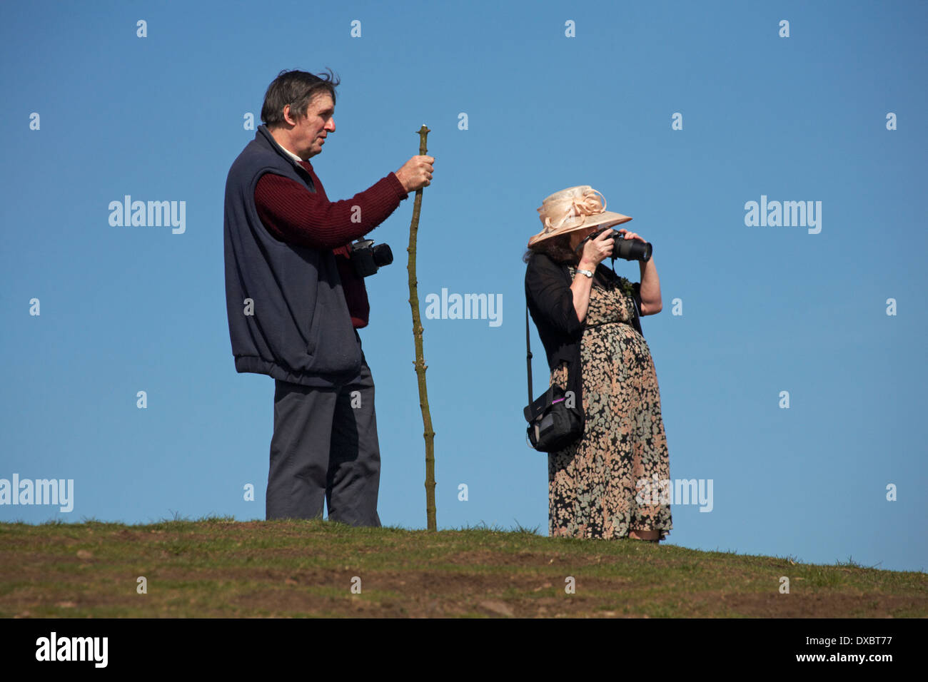 Mann und Frau, Teil der Hochzeitsgesellschaft, Fotografieren bei The Beacon in den Malvern Hills, Great Malvern im April Stockfoto