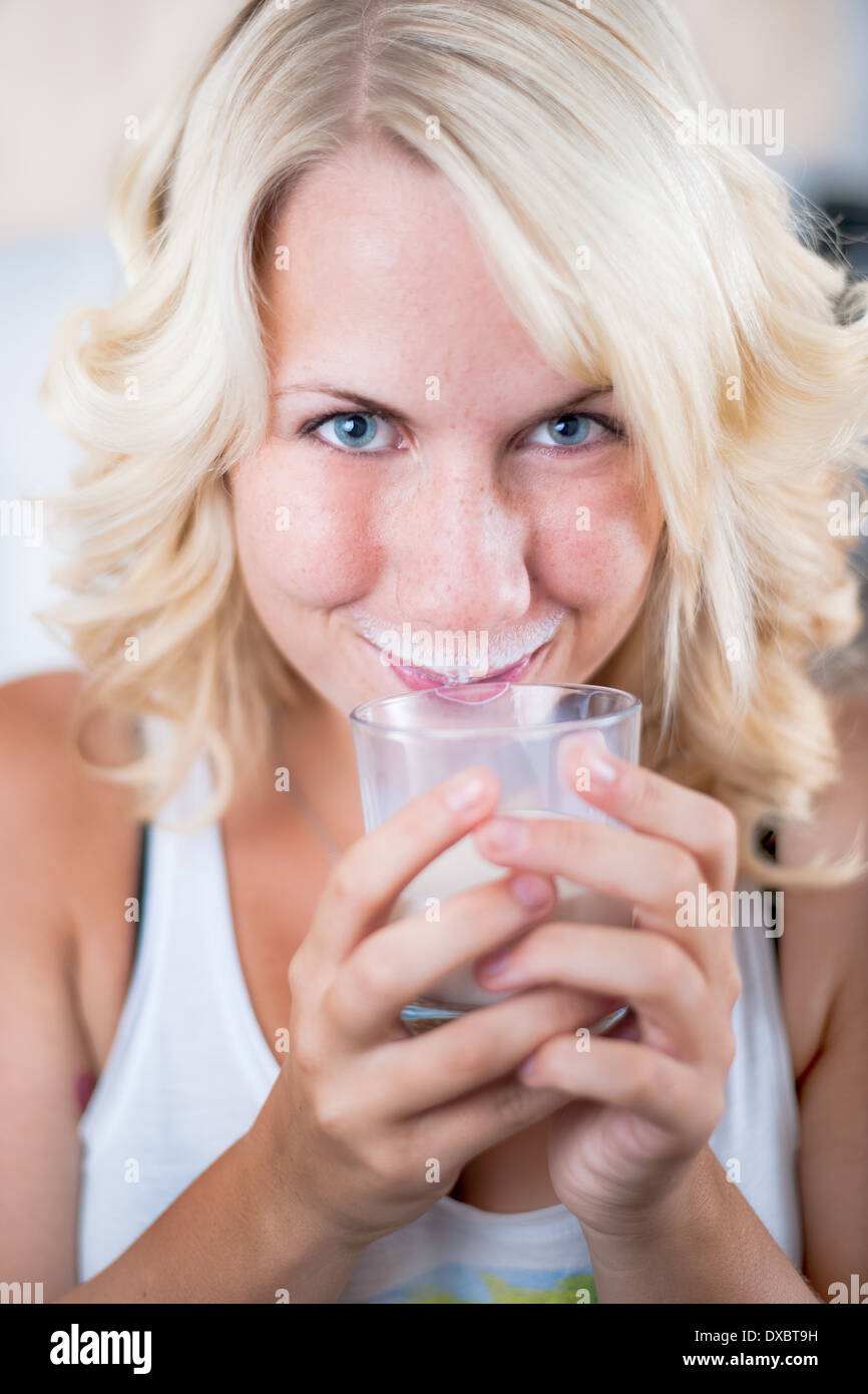 junge Frau mit einem Glas Milch in der Küche Stockfoto