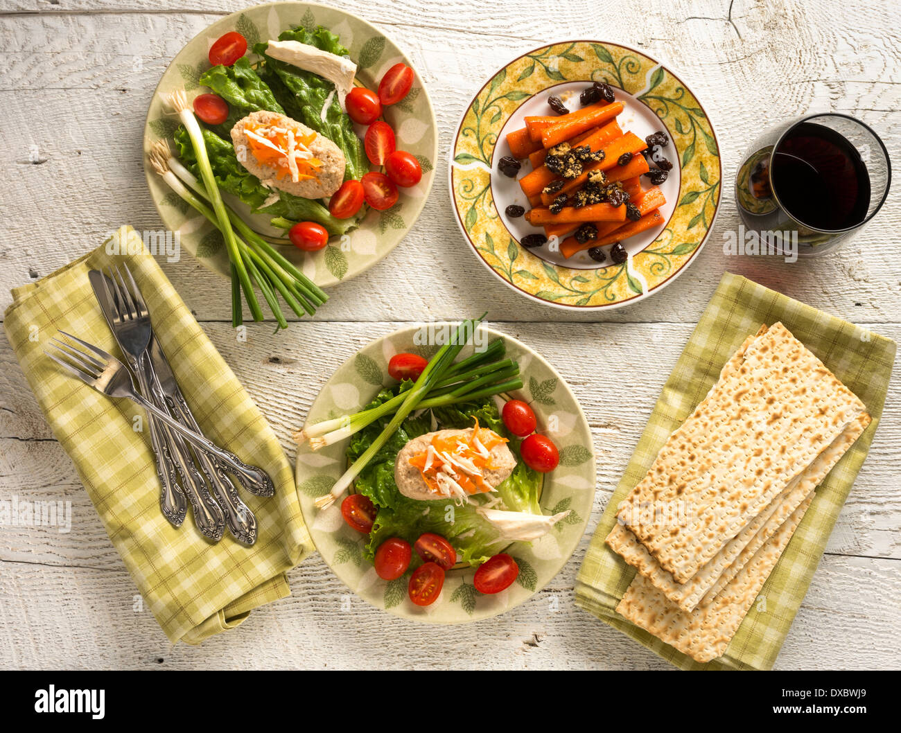 Traditionelle Gerichte der jüdischen Pessach Gefillte Fisch und Tsimmes mit Rotwein und Matza auf weißem Holz Stockfoto