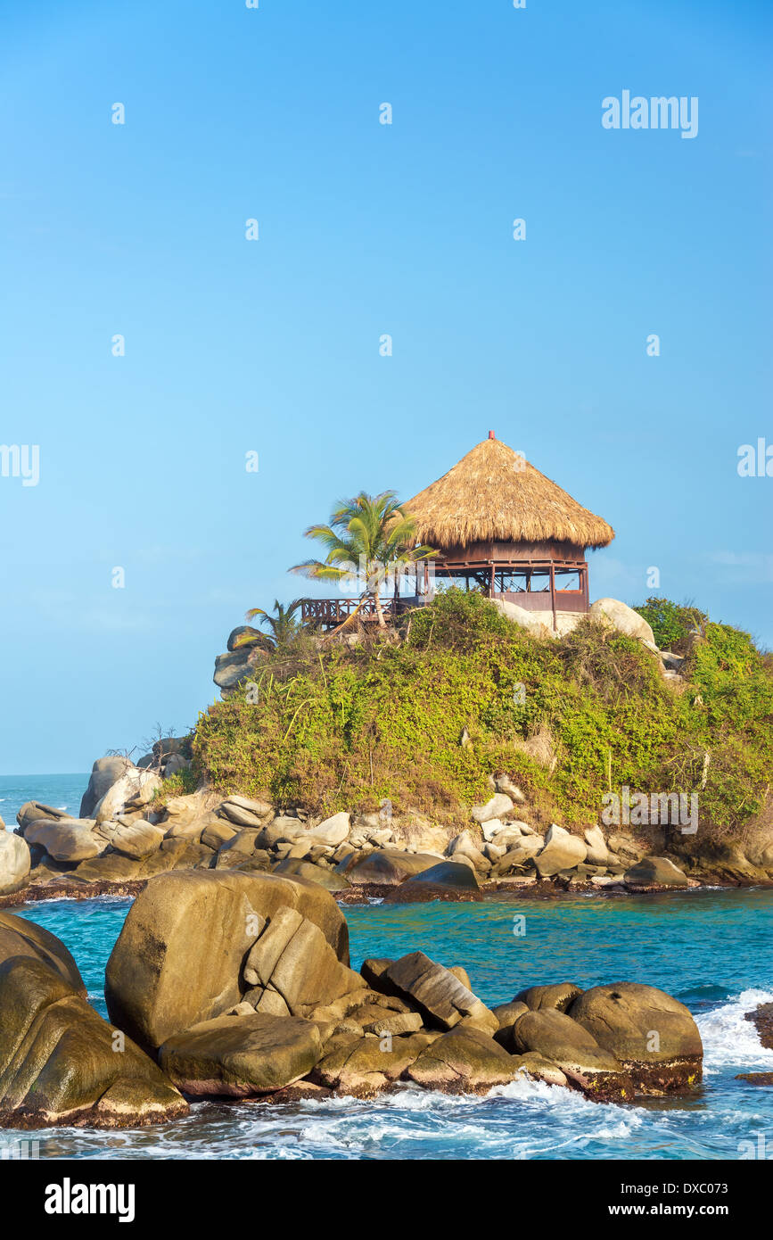 Kleine Hütte mit einer Palme mit blauen karibischen Meerwasser im Tayrona Nationalpark in Kolumbien Stockfoto