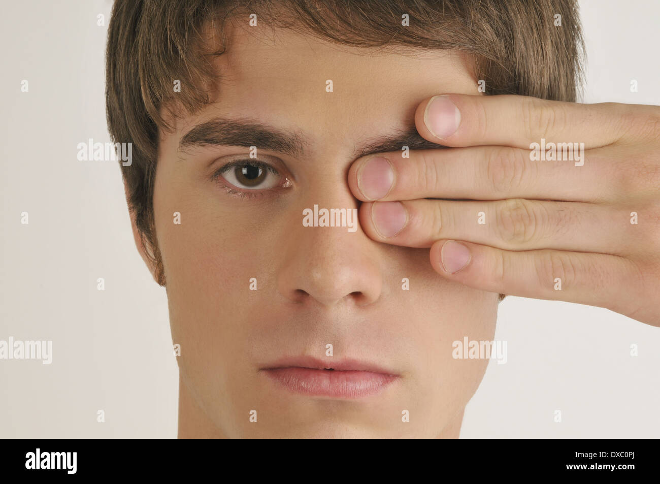 Junge männliche Erwachsene, Hand abdecken eines Auges Stockfoto