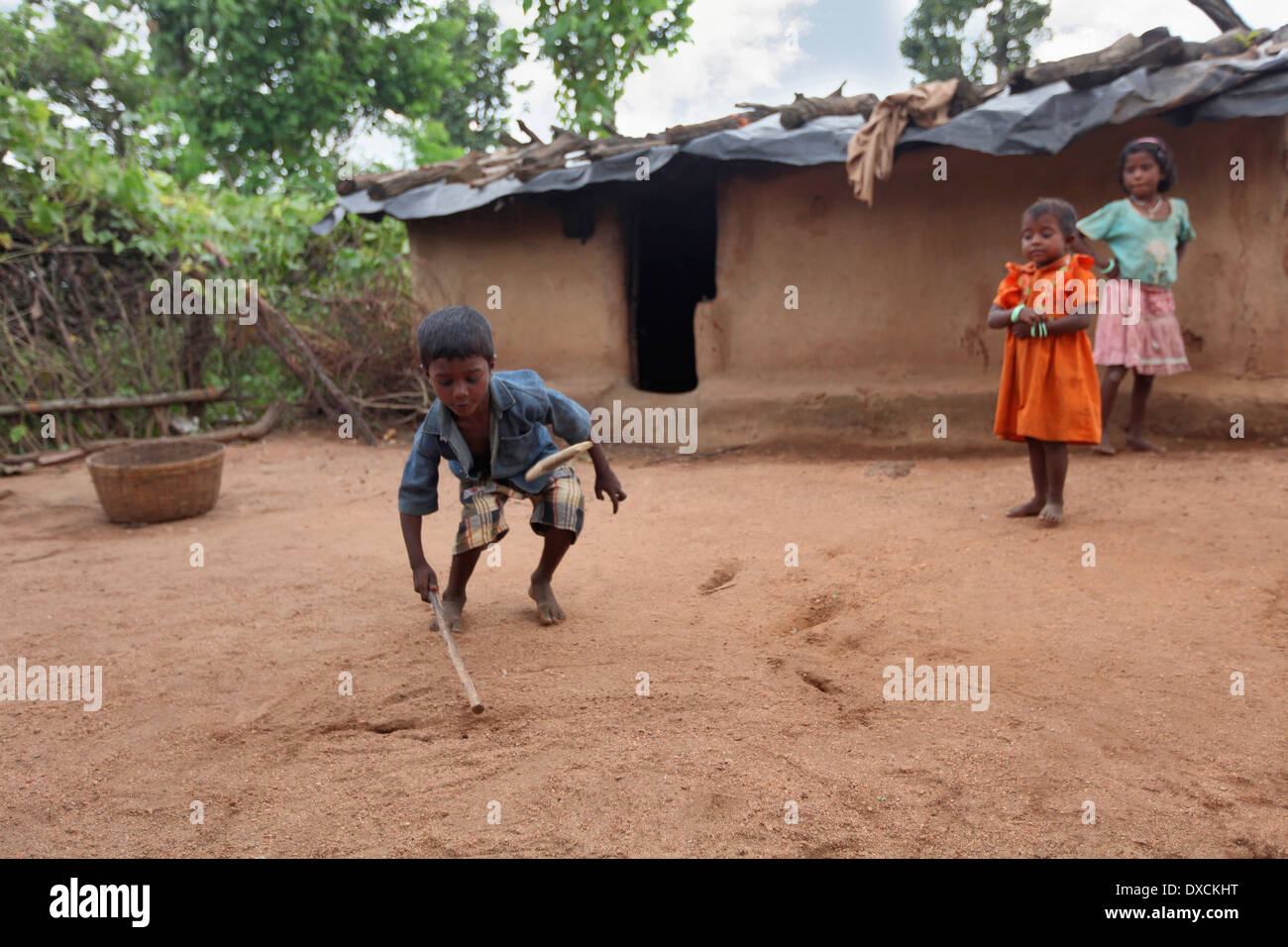 Stammes-Kinder spielen Gulli-Danda im Hof eines Hauses. Malhar Kaste Kinder. Bezirk Hazaribaug, Jharkhand Stockfoto