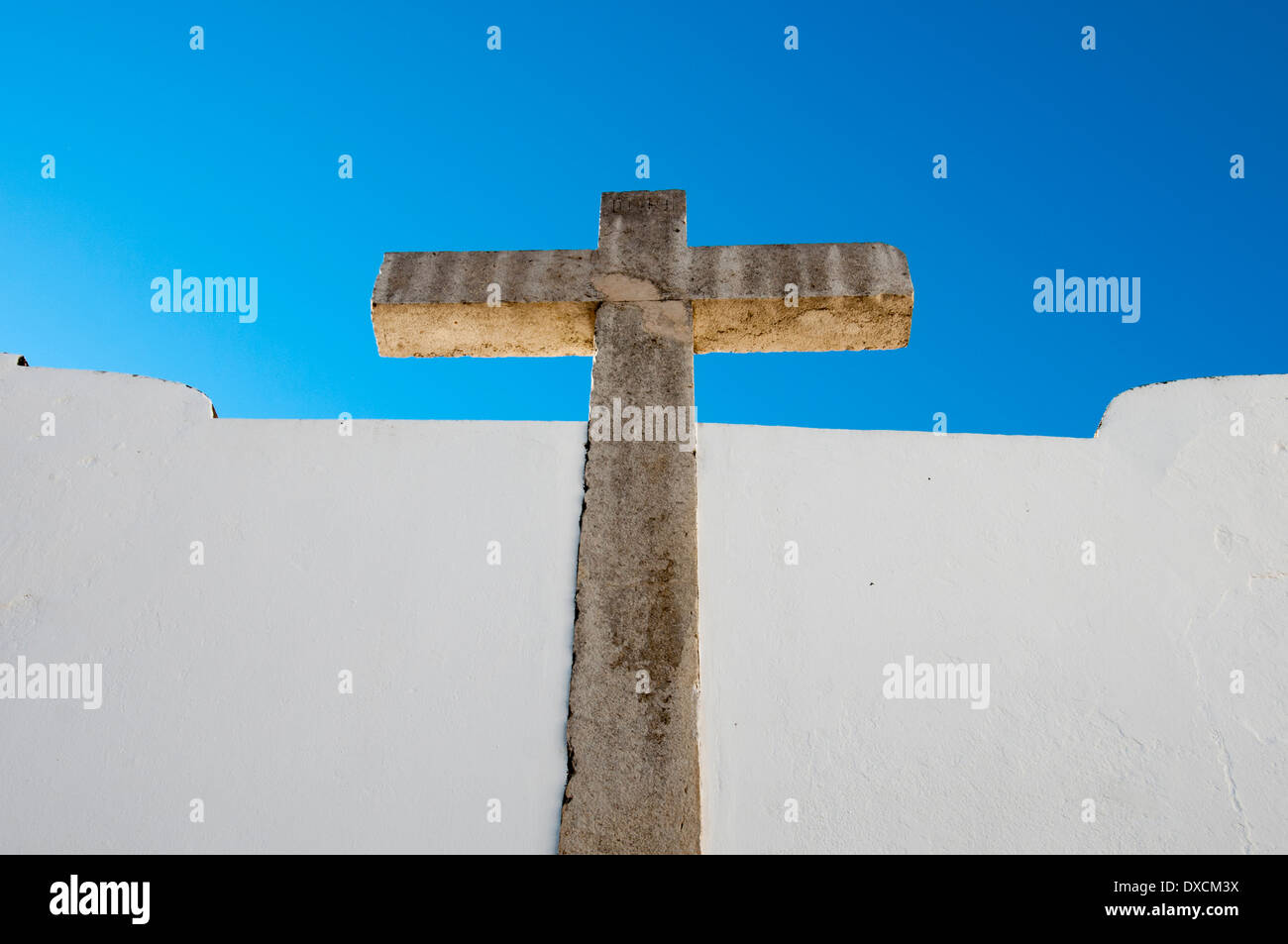 religiöse Steinkreuz an weiß getünchten Wand in der alten Stadt Faro, Algarve, Portugal Stockfoto