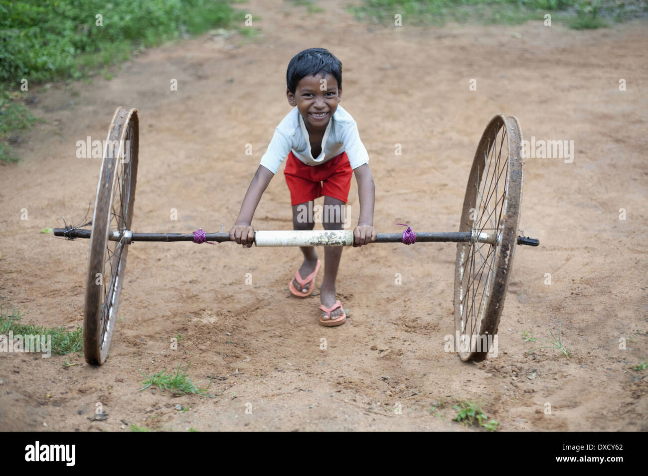 Tribal mit Zyklus Räder spielende Kinder. Munda Stamm. Bartoli Dorf Khunti Bezirk Ranchi, Jharkhand, Indien Stockfoto