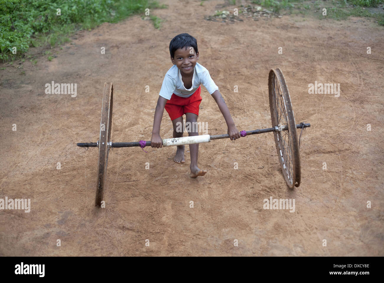 Munda Stammes-Kind spielt mit Zyklus Räder. Bartoli Dorf Khunti Bezirk Ranchi, Jharkhand, Indien Stockfoto