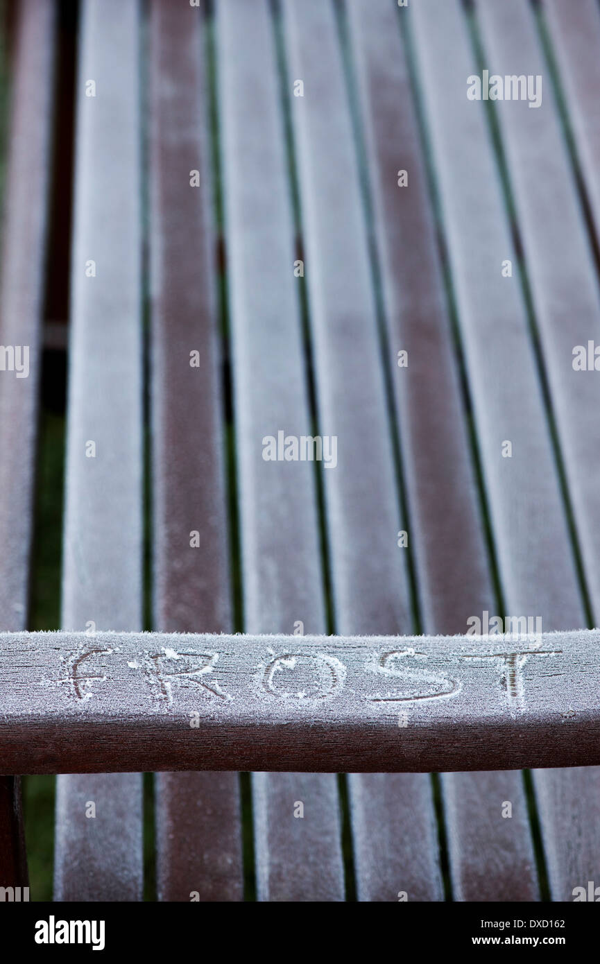 Frost auf eine Gartenbank im Frühjahr. UK Stockfoto