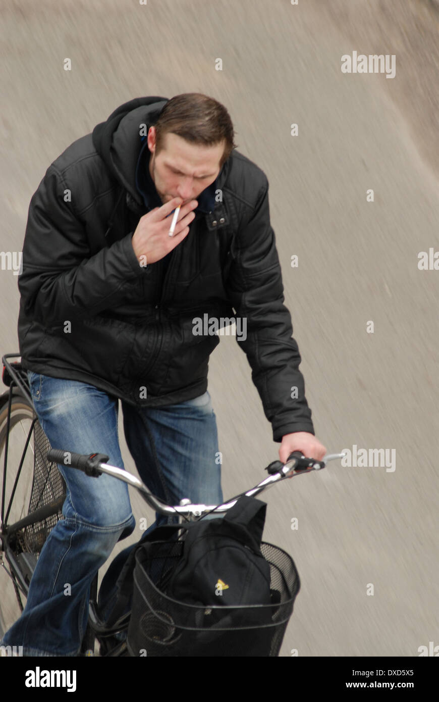 Ein Mann Rauchen während der Fahrt mit dem Fahrrad. Stockfoto