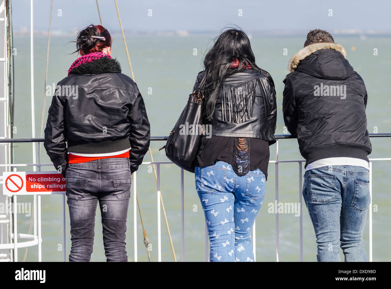 3 Personen stehen auf einer Fähre, Blick auf das Meer. Stockfoto
