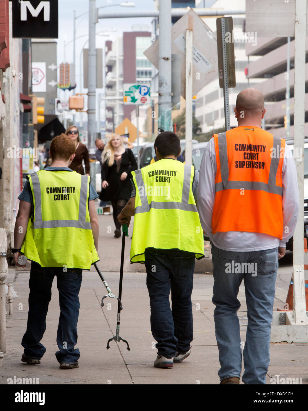 Junge Männchen verwenden Reichweite und Pick-up Werkzeug zur Abholung Müll als Bestandteil ihrer Zivildienst in der Innenstadt von Austin, Texas Stockfoto