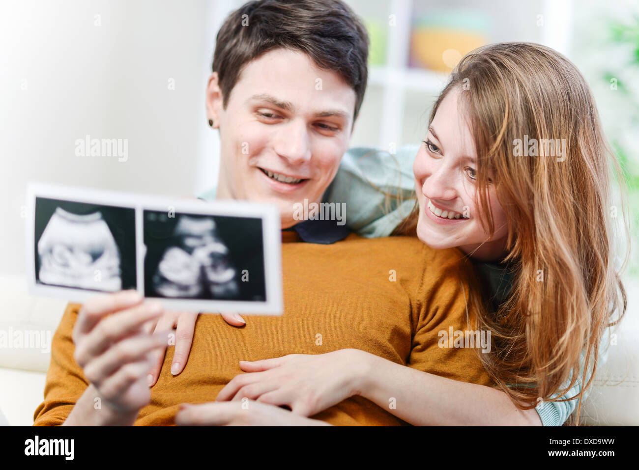 Schönes paar beobachten mit Emotion Ultraschallbilder ihres Babys Stockfoto