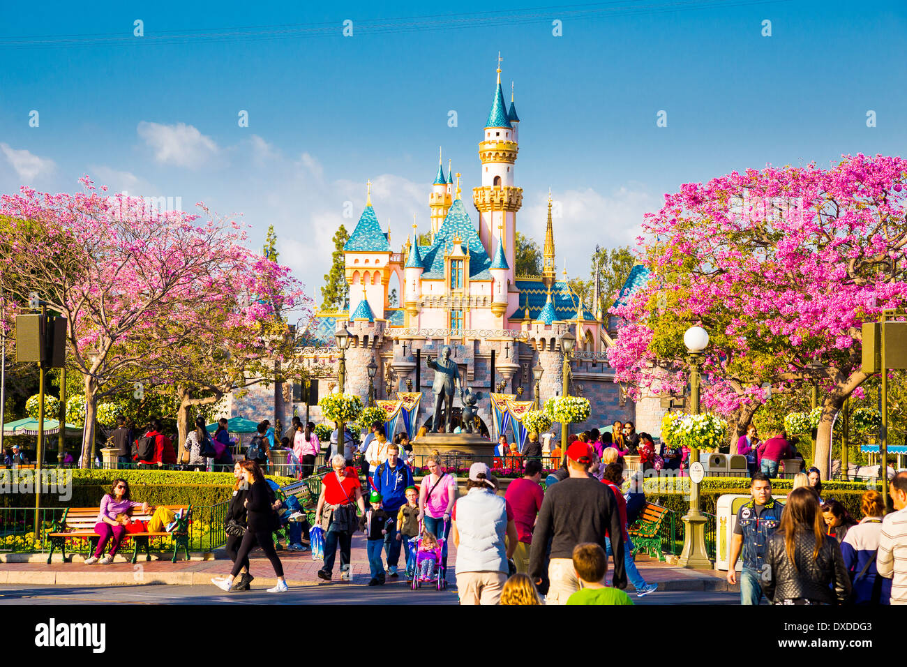 Disneyland Main Street überfüllt mit Gästen und eine Straßenbahn-Auto auf der Straße in Richtung der berühmten Rosa Schloss. Stockfoto