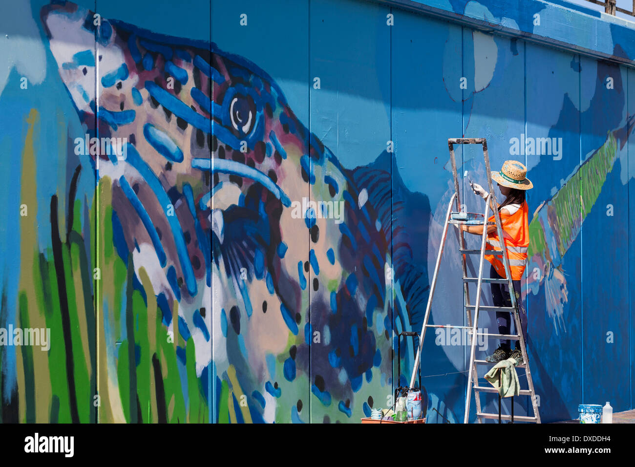 Kunststudenten malen ein Wandbild an der Hafenmauer in Los Cristianos-Teneriffa-Kanarische Inseln-Spanien Stockfoto
