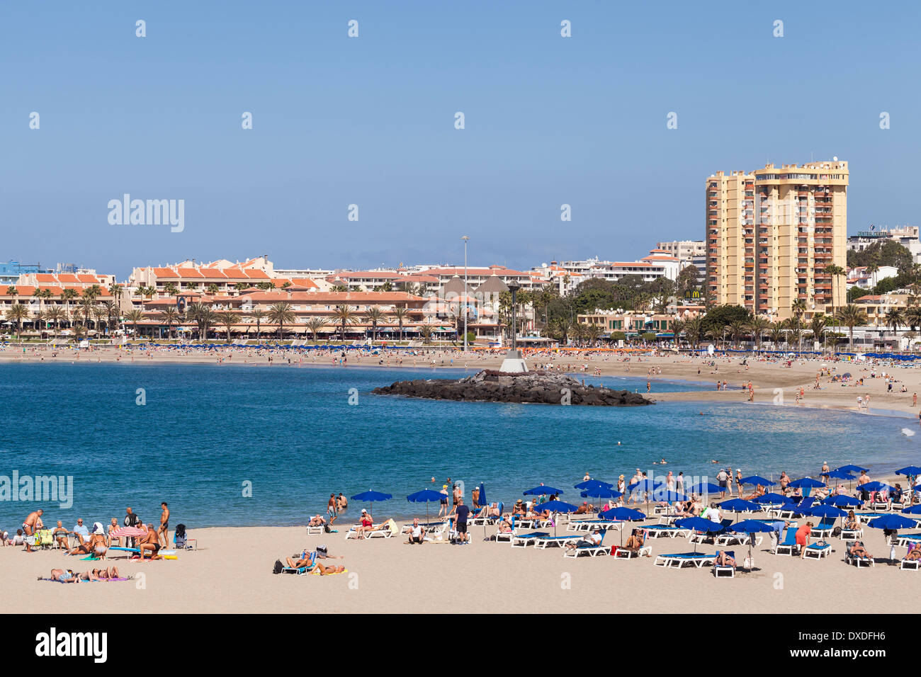Sonnenbaden am Playa Las Vistas in Los Cristianos, Teneriffa, Kanarische Inseln, Spanien Torres del Sol Hochhaus Hintergrund Touristen Stockfoto