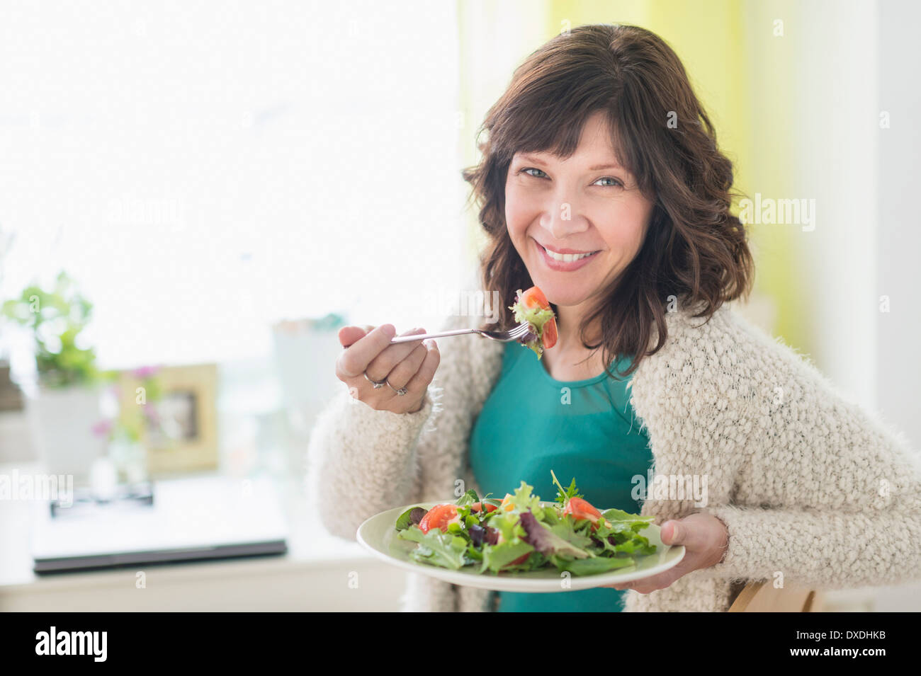 Frau zu Hause essen Salat Stockfoto