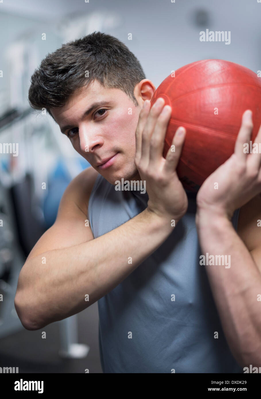 Junger Mann im Fitnessstudio halten Medizinball Stockfoto