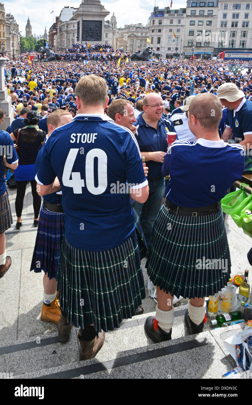 Rückansicht von zwei schottischen Fußballfans, die Kilts auf dem überfüllten sonnigen Trafalgar Square tragen, bevor sie zum internationalen Spiel im Wembley England Großbritannien übergehen Stockfoto