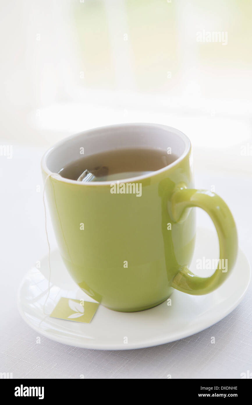 Tasse Tee im grünen Tasse mit Untertasse, Studioaufnahme Stockfoto