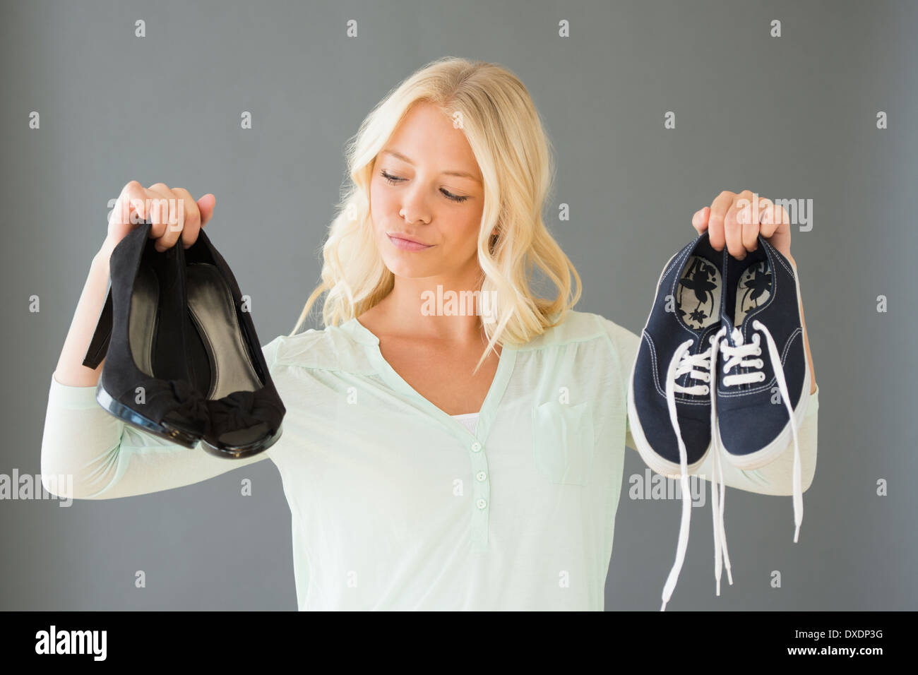 Porträt der jungen Frau hält Schuhe Stockfoto