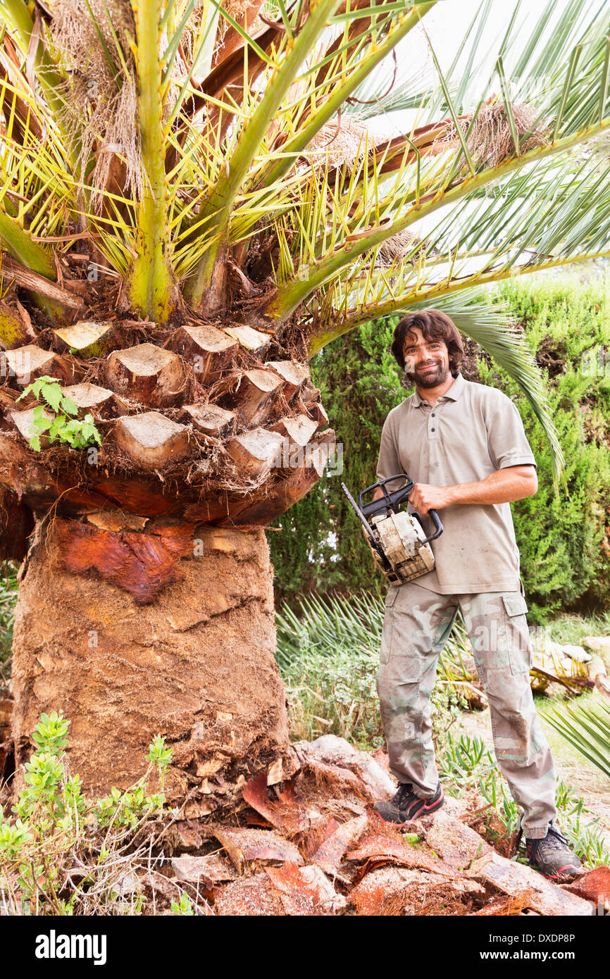 Porträt von Mann mit Kettensäge zum Schälen von Palme, Mallorca, Spanien Stockfoto
