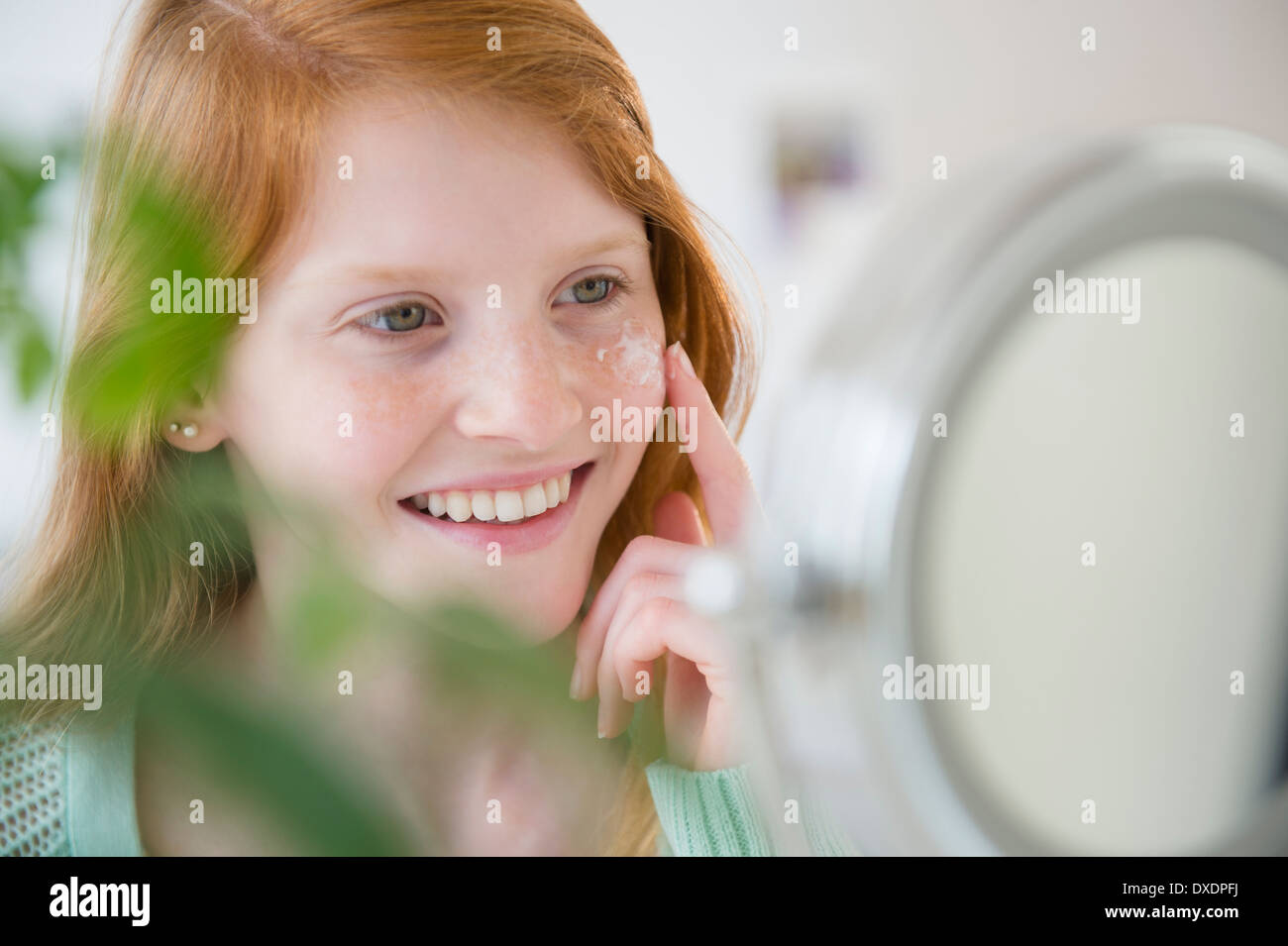 Mädchen (12-13) anwenden Feuchtigkeitscreme Stockfoto