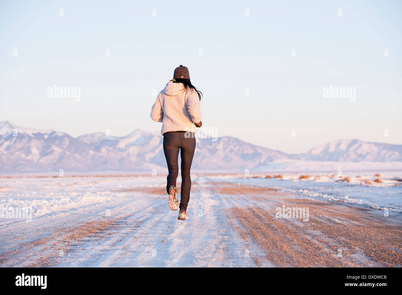 Rückansicht der Frau läuft im Winter Landschaft, Colorado, USA Stockfoto