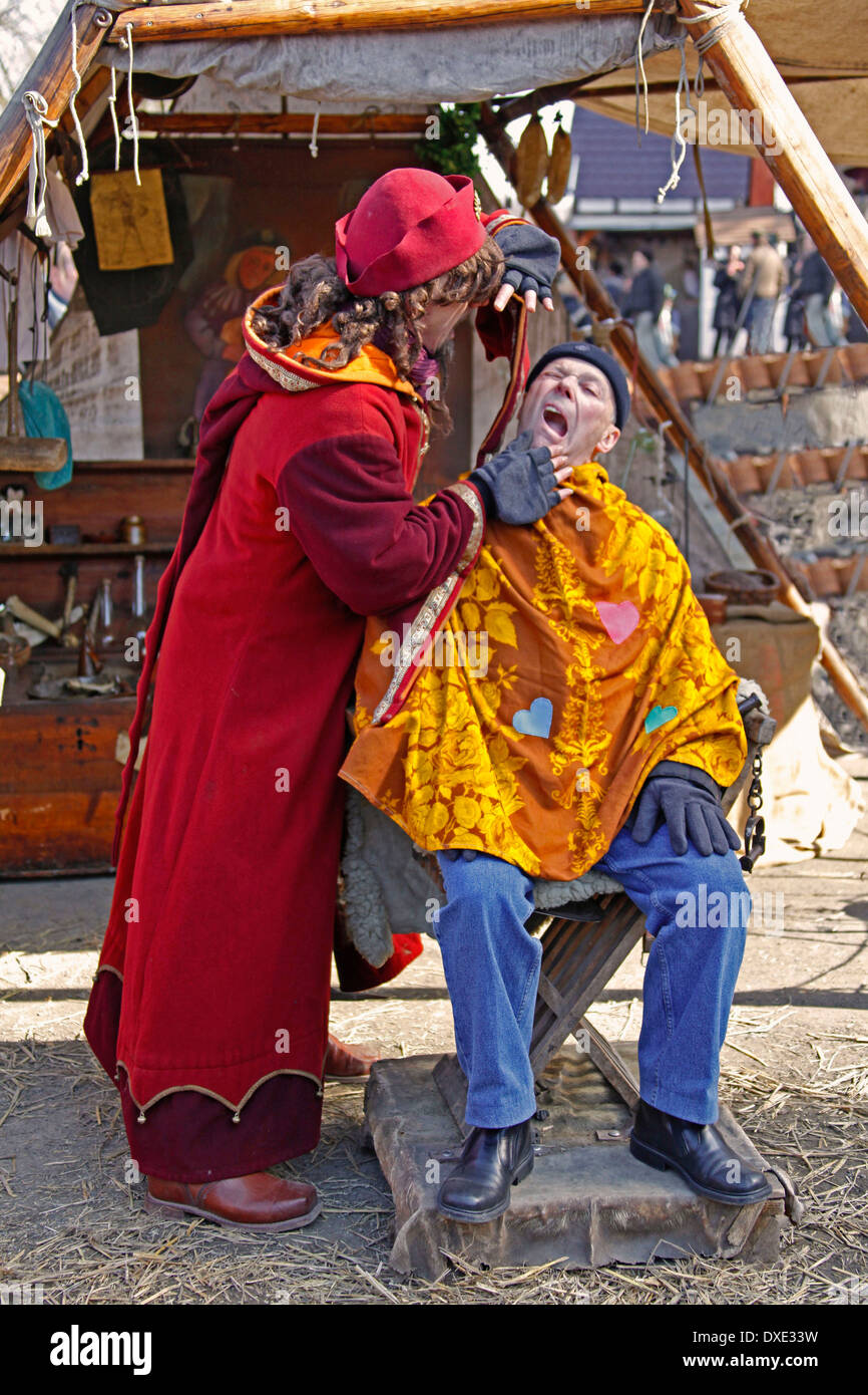 Mittelalterlicher Ostermarkt Renaissance Festival mittelalterlichen gekleidet Barbier nimmt ein Patient einen Zahn Ronneburg Schloss Gemeinde Stockfoto