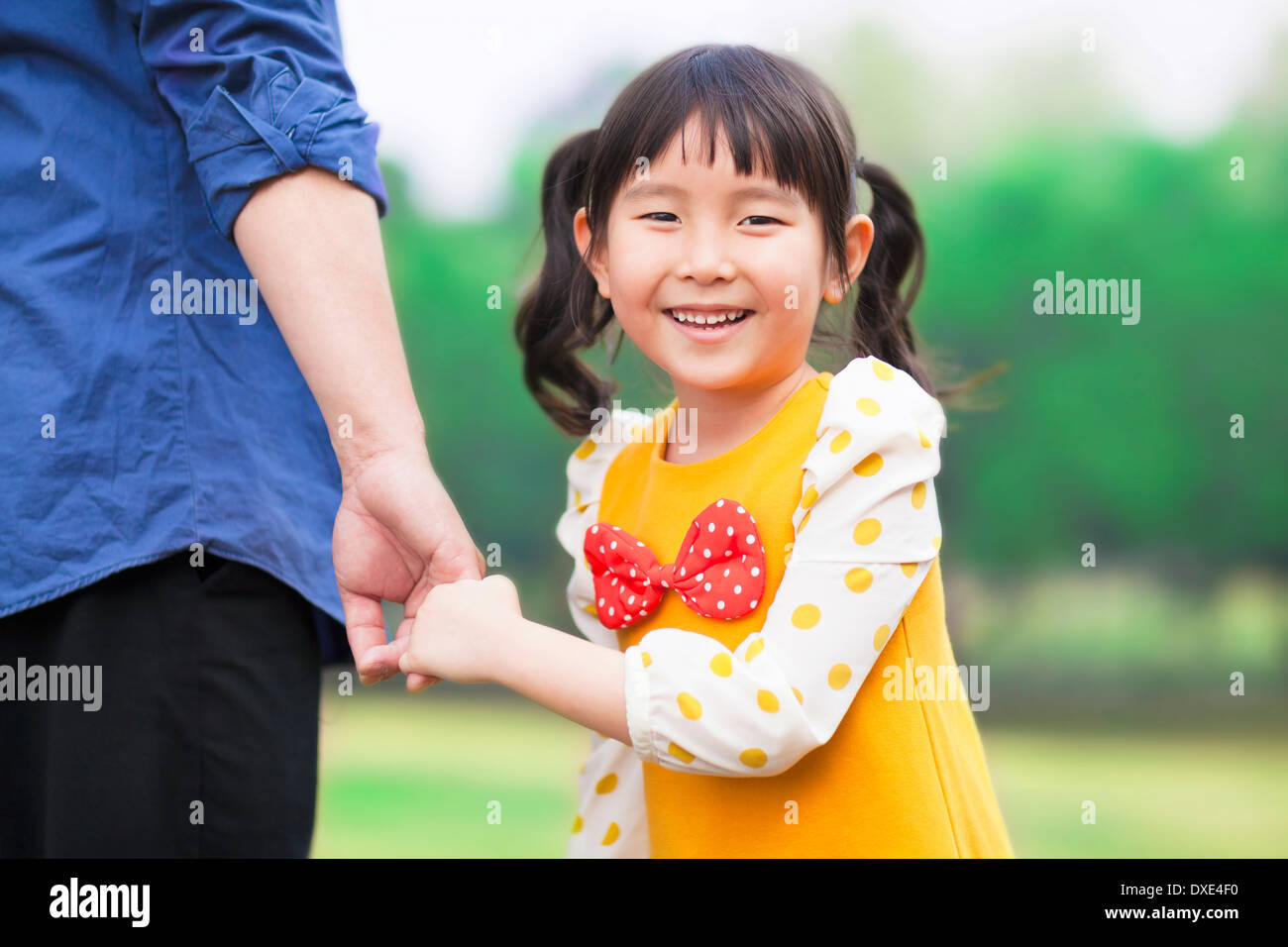 hübsches Mädchen Vater Hand halten im park Stockfoto